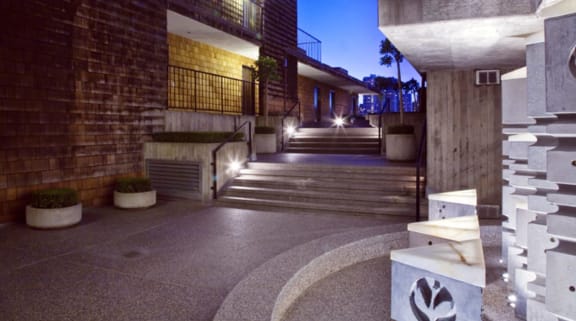 a view of a building at night with stairs in the foreground and a staircase in the background