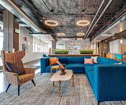 a lobby with blue couches and chairs and a coffee table