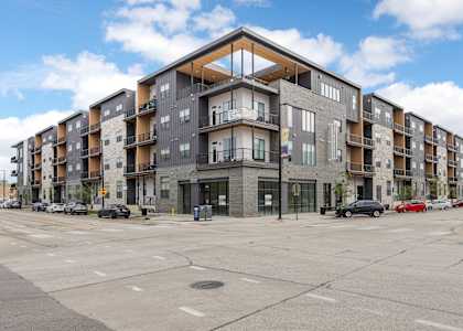 A large apartment building with a parking lot in front.