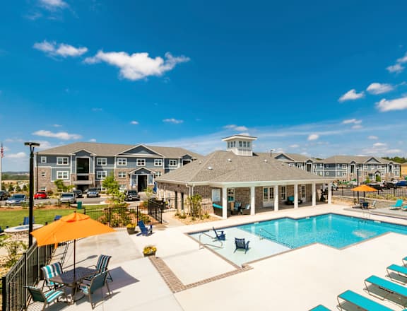 A pool area with sun loungers and a gazebo.