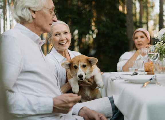 people sitting at a table with a dog