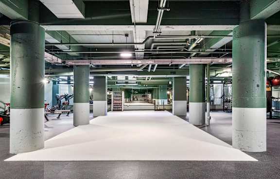 a large white rug in a building with columns