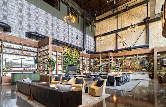 the lobby of a hotel with a large open lobby area with couches and tables