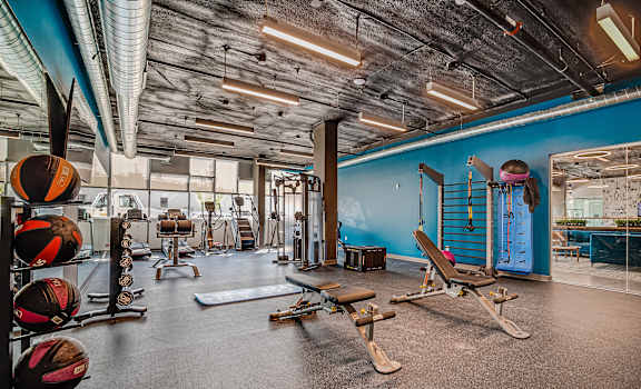 a gym with weights and other exercise equipment and a blue wall