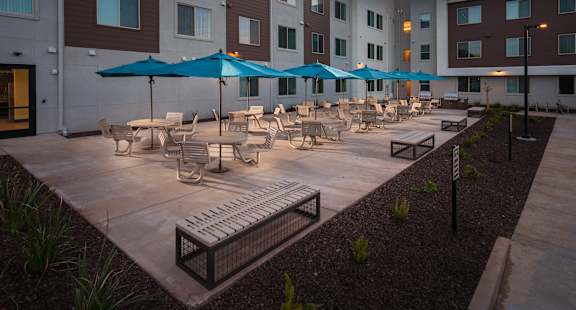 a courtyard with tables and chairs and umbrellas