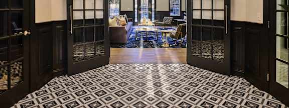 A room with a black and white tiled floor and a glass door.