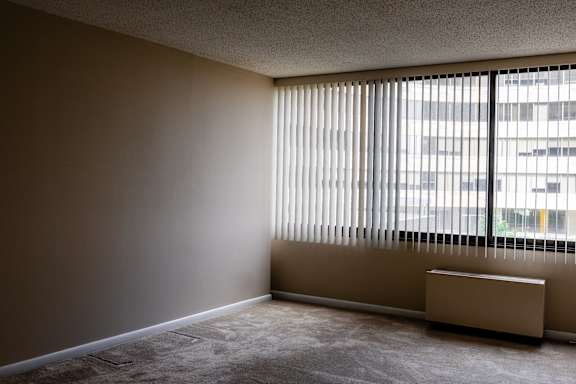 A room with a window covered by blinds and a radiator on the floor at Hampton Plaza Apartments, Towson, MD, 21286