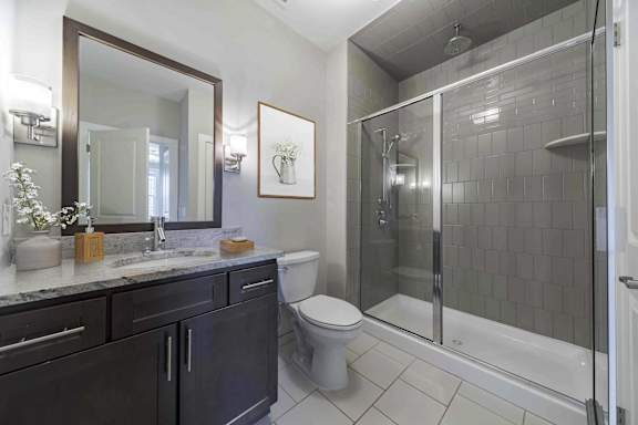 A bathroom with a toilet, sink, and shower.