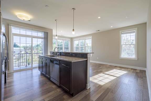 A modern kitchen with dark wood floors and a large island.