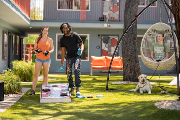 A man and a woman are playing a game on a lawn.