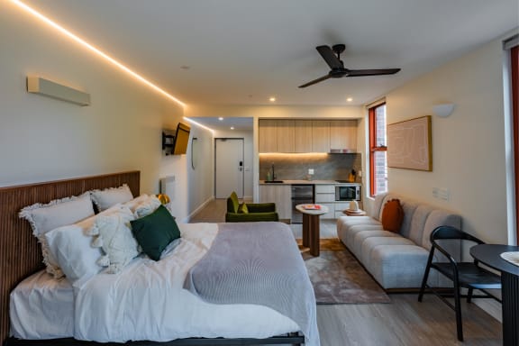 a bedroom with two beds and a living room with a kitchen