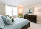 Thumbnail 11 of 23 - bedroom at VistaView apartments in Frederick, MD with bed with blue linens, dresser and chair at VistaView, Maryland, 21702