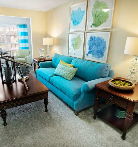 A living room with a blue couch and a brown coffee table.