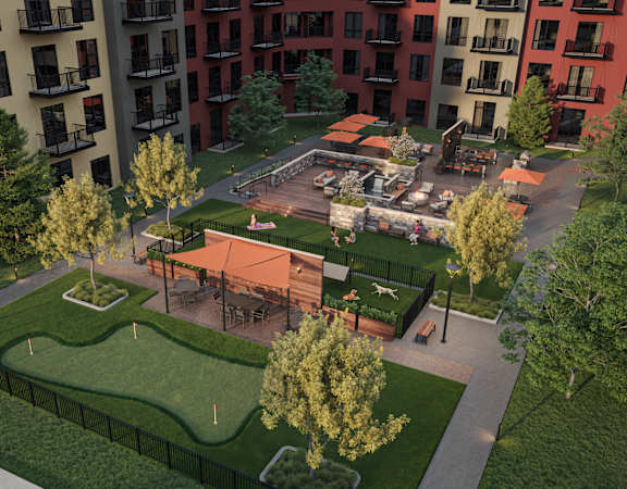 A park area with a playground and a green lawn surrounded by apartment buildings.