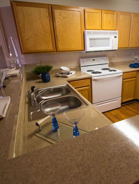A kitchen with wooden cabinets and a white refrigerator.
