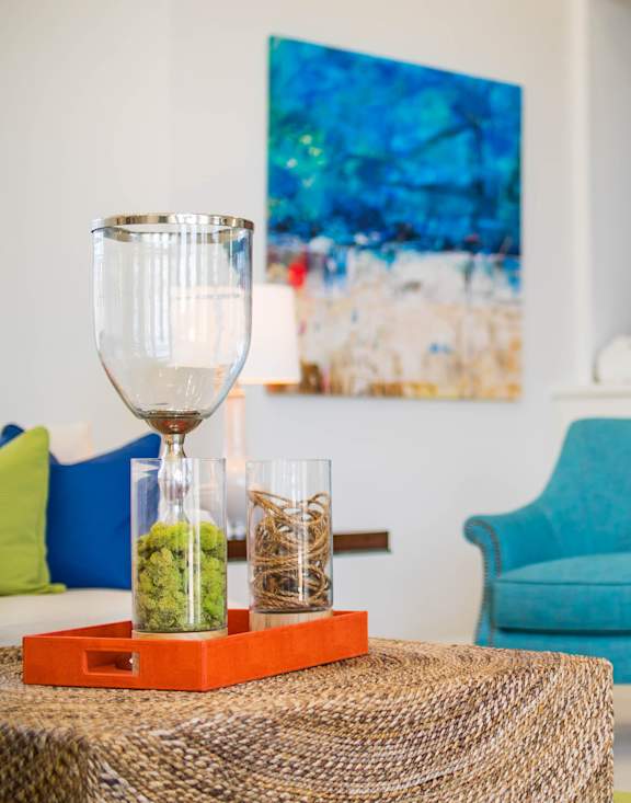 A living room with blue chairs and a painting on the wall.