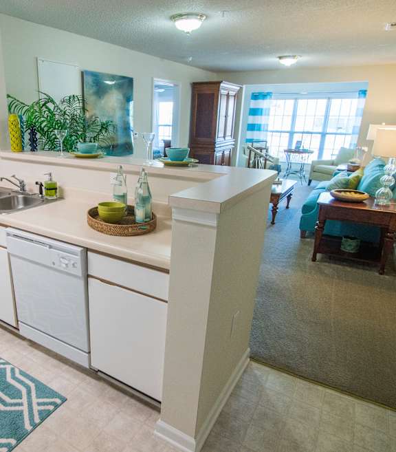 A kitchen with white cabinets and a blue patterned rug.