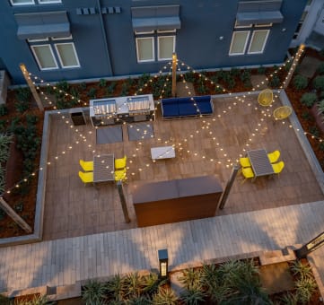 an aerial view of a patio with yellow chairs and string lights