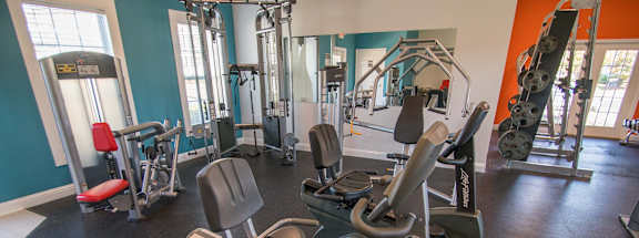 A gym with a rowing machine in the foreground.