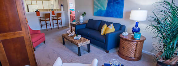 A living room with a white couch and a blue couch.