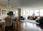 Thumbnail 1 of 2 - A living room with a glass table and chairs at Hampton Plaza Apartments, Towson, MD, 21286