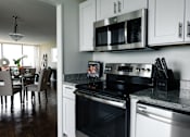 Thumbnail 4 of 4 - A modern kitchen with a stove top oven and microwave above it at Hampton Plaza Apartments, Towson, MD, 21286