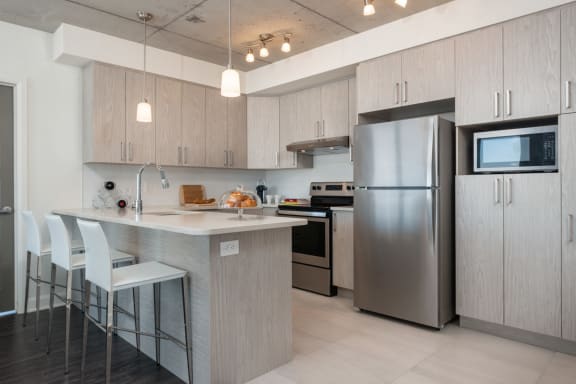 a kitchen with stainless steel appliances and an island with stools