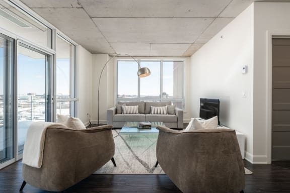 a living room with two chairs and a couch and a tv