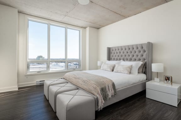 a bedroom with a bed and a large window