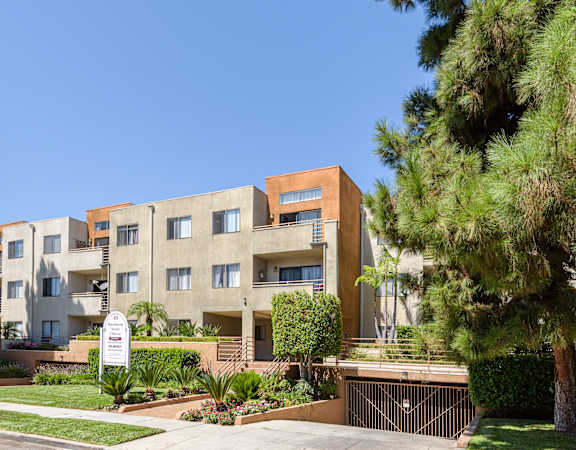 an apartment building with a sign in front of it