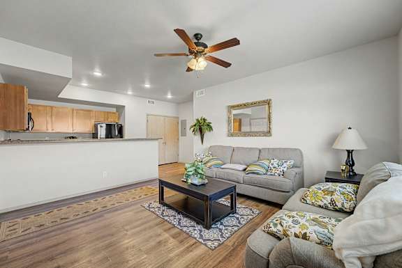 A living room with two couches, a coffee table, and a ceiling fan.