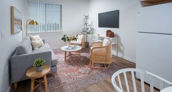 a living room with white walls and hardwood floors