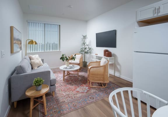 a living room with white walls and hardwood-look floors