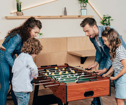 A family playing a game of foosball together.