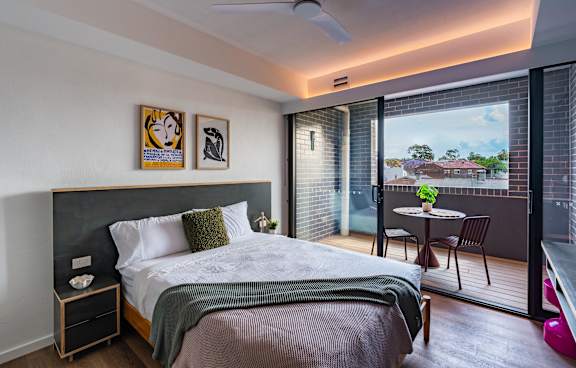 a living room with a green couch and a balcony