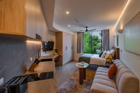 a hotel room with a bed and a kitchen