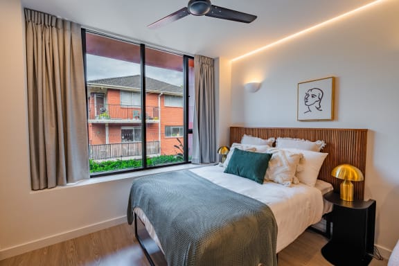 a bedroom with a large window and a bed