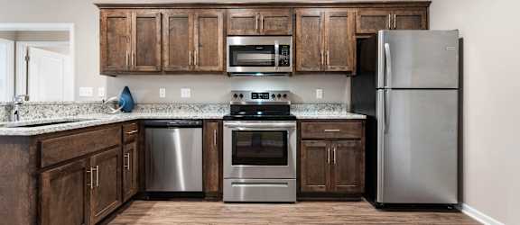 A kitchen with wooden cabinets and stainless steel appliances.