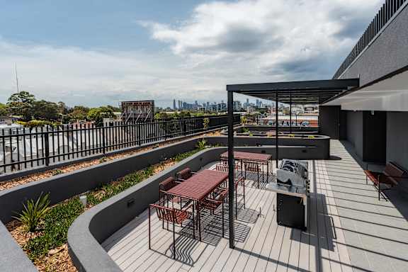 a roof terrace with tables and chairs and a view of the city