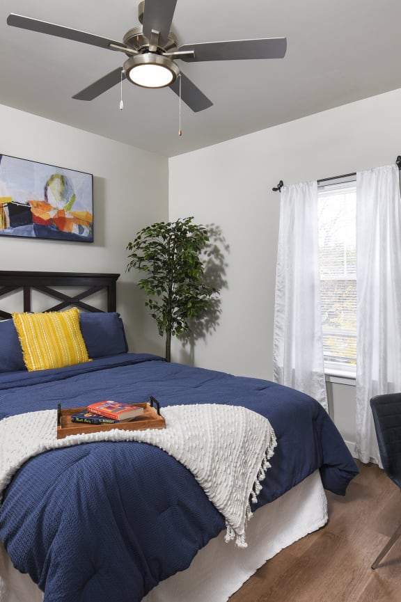 a bedroom with a bed and a ceiling fan
