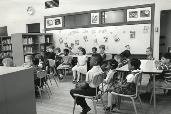 a group of children sitting at desks in a classroom