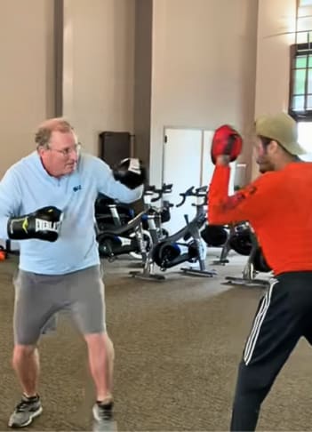two men are in a gym playing with a ball