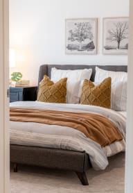 a bedroom with a bed and pillows and pictures on the wall