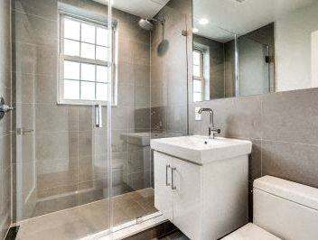 A white sink is on a white cabinet in a bathroom.