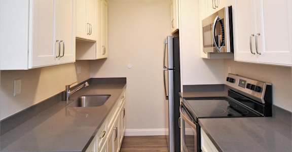 a kitchen with white cabinets and stainless steel appliances