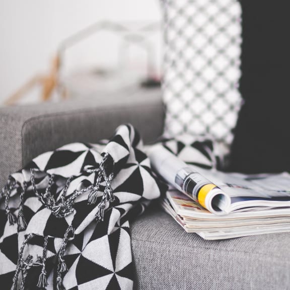 a pile of papers and a newspaper on a couch