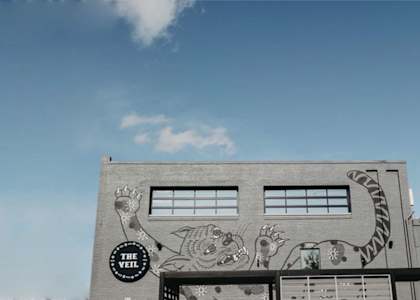 A building with a mural on the side and a sign that says "The Brew".