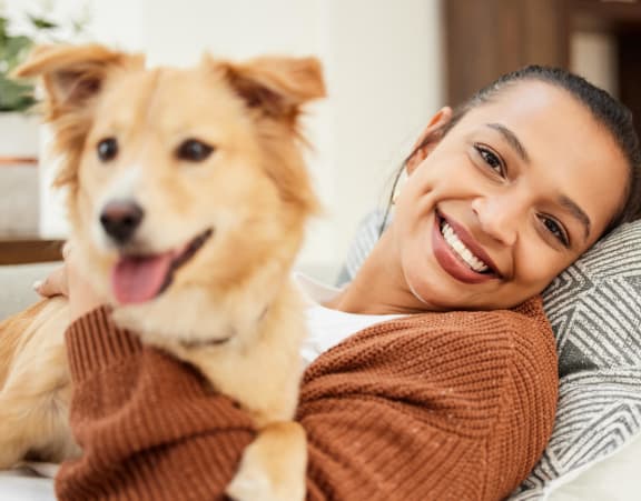 a woman laying on a bed with a dog