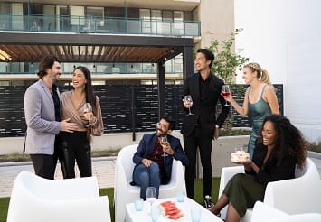a group of people sitting and drinking wine