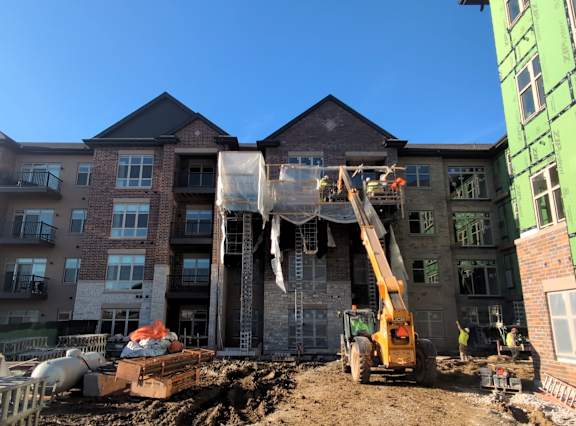 A construction site with a crane and a building under construction.